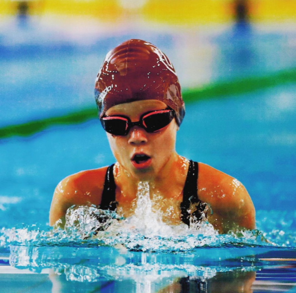 A young girl in a swimming race in the pool